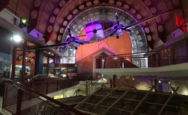 Plane hanging from the roof of museum with purple lighting